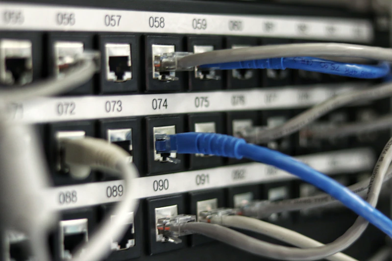 Sala de servidores com fileiras de racks e luz azulada