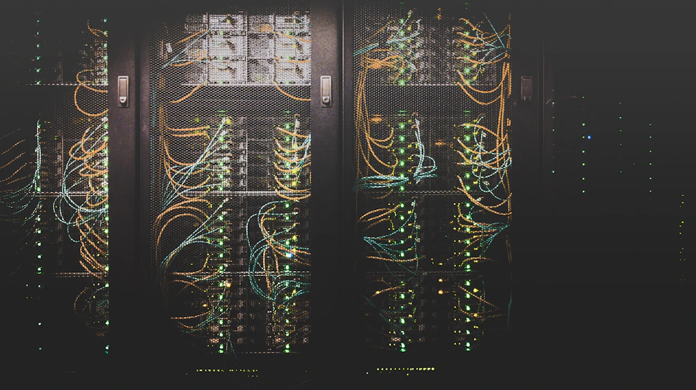 Corredor de data center com cabos organizados e iluminação lateral